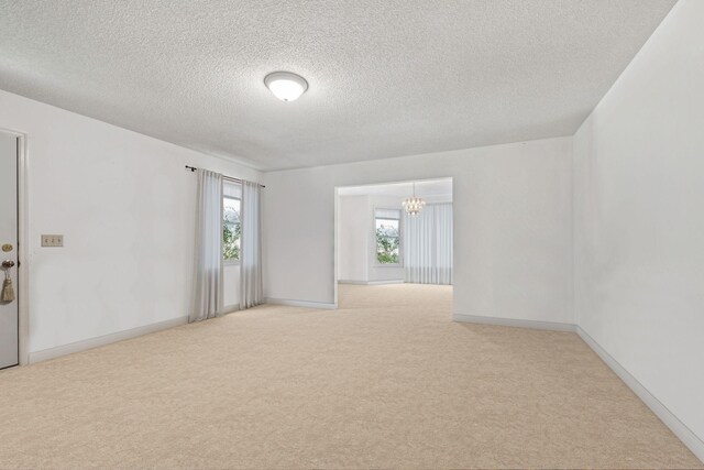 8663 Dog Branch Rd, Mount Pleasant, TN 38474 - carpeted empty room with a chandelier and a textured ceiling