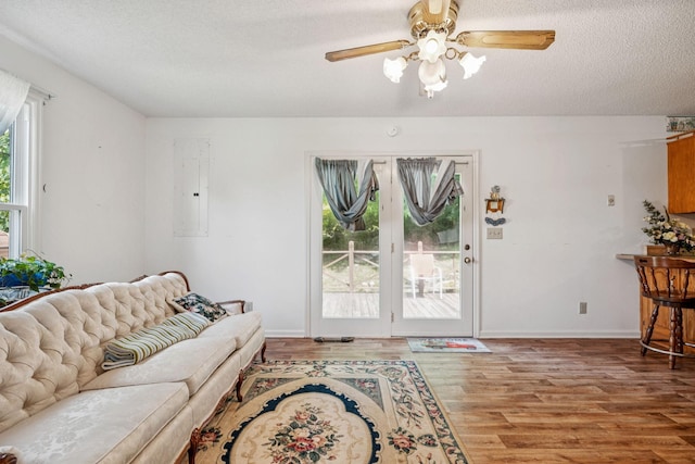8663 Dog Branch Rd, Mount Pleasant, TN 38474 - living room featuring electric panel, light wood-style flooring, a ceiling fan, and a textured ceiling