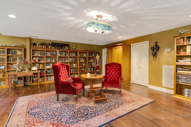 997 W 12th St, Chickamauga, GA 30707 - sitting room with a textured ceiling, wood finished floors, recessed lighting, and wall of books