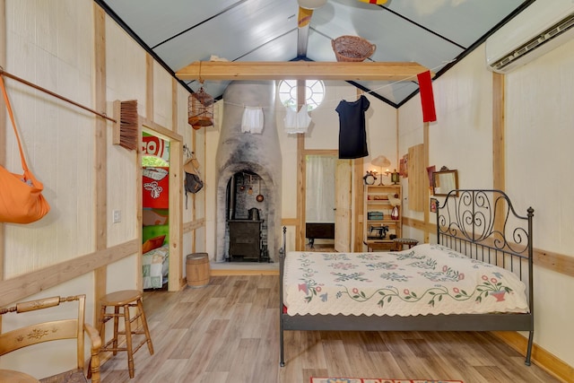 997 W 12th St, Chickamauga, GA 30707 - bedroom with a wood stove, an AC wall unit, wood finished floors, and vaulted ceiling