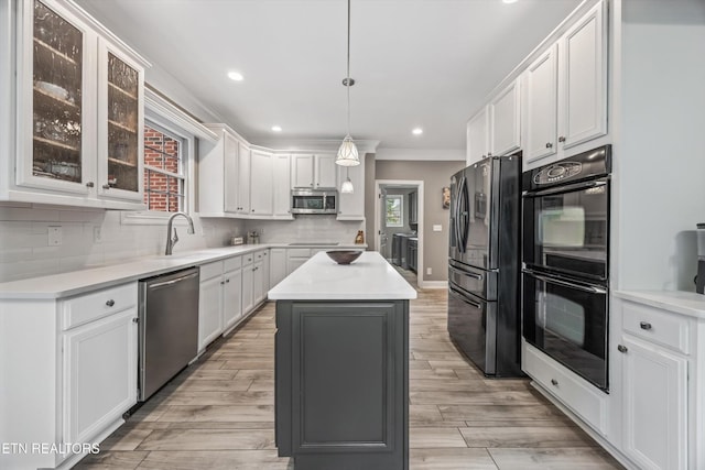 108 Center Park Ln, Oak Ridge, TN 37830 - kitchen with black appliances, white cabinets, a kitchen island, ornamental molding, and backsplash