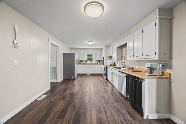 3205 Sylvia Rd, Dickson, TN 37055 - kitchen with stainless steel appliances, dark wood finished floors, light countertops, white cabinetry, and under cabinet range hood