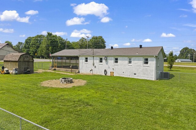3205 Sylvia Rd, Dickson, TN 37055 - back of property featuring a fire pit, a fenced backyard, a storage shed, and a sunroom