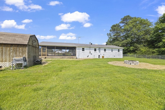 3205 Sylvia Rd, Dickson, TN 37055 - rear view of house with a sunroom, an outdoor fire pit, and a storage shed