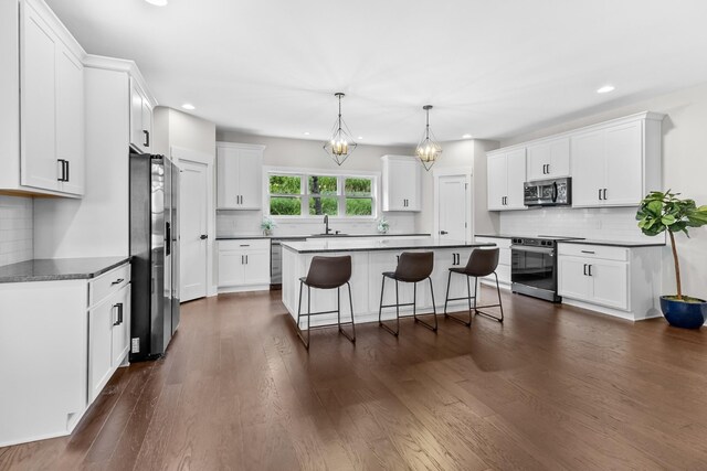 1227 N Avondale Cir, Nashville, TN 37207 - kitchen featuring appliances with stainless steel finishes, a breakfast bar, backsplash, recessed lighting, and white cabinets