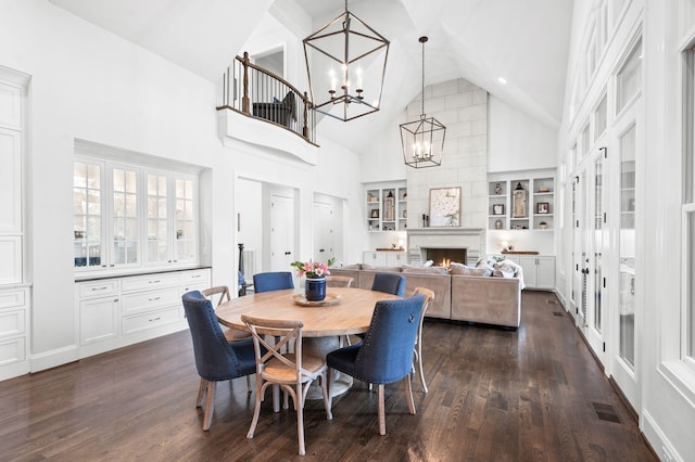 1542 Amesbury Ln, Franklin, TN 37069 - dining room with a chandelier, high vaulted ceiling, dark wood-style flooring, built in shelves, and a lit fireplace