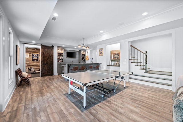 1542 Amesbury Ln, Franklin, TN 37069 - game room with a barn door, light wood-style flooring, recessed lighting, ornamental molding, and a tray ceiling