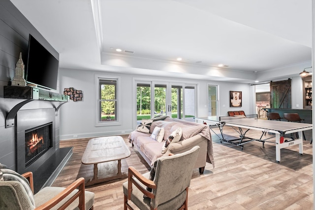 1542 Amesbury Ln, Franklin, TN 37069 - living area featuring a tray ceiling, light wood-type flooring, a warm lit fireplace, crown molding, and recessed lighting