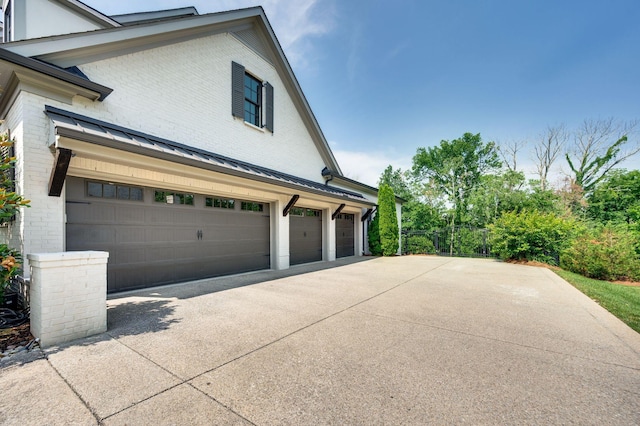 1542 Amesbury Ln, Franklin, TN 37069 - view of property exterior featuring concrete driveway, brick siding, a standing seam roof, and a metal roof