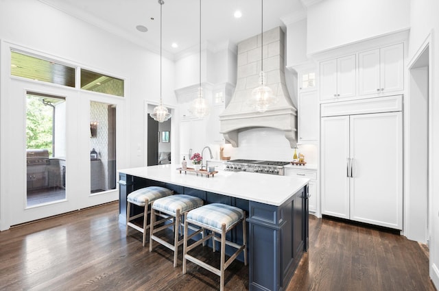 1542 Amesbury Ln, Franklin, TN 37069 - kitchen featuring paneled fridge, white cabinets, light countertops, a kitchen island with sink, and ornamental molding