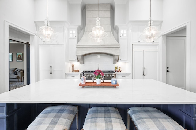 1542 Amesbury Ln, Franklin, TN 37069 - kitchen featuring wall chimney exhaust hood, a chandelier, a large island with sink, backsplash, and white cabinets