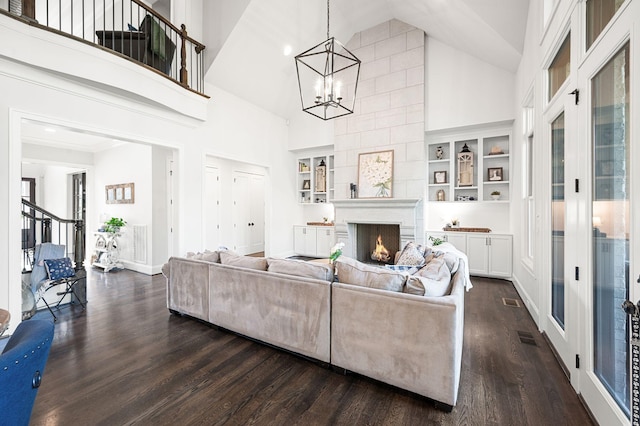 1542 Amesbury Ln, Franklin, TN 37069 - living area with high vaulted ceiling, dark wood-type flooring, a chandelier, and a warm lit fireplace