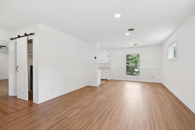 415 Porter Cir, Columbia, TN 38401 - unfurnished living room featuring a barn door, light wood-type flooring, and recessed lighting
