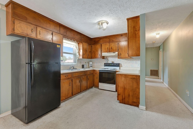 303 Furnace Hollow Rd, Dickson, TN 37055 - kitchen with freestanding refrigerator, white range with electric cooktop, under cabinet range hood, brown cabinets, and light countertops