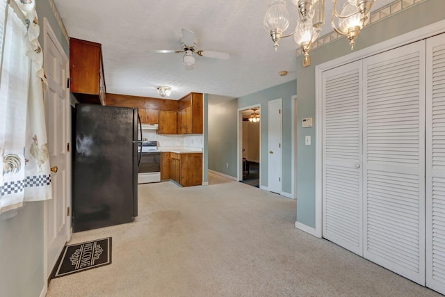 303 Furnace Hollow Rd, Dickson, TN 37055 - kitchen with freestanding refrigerator, electric stove, brown cabinets, a ceiling fan, and a textured ceiling