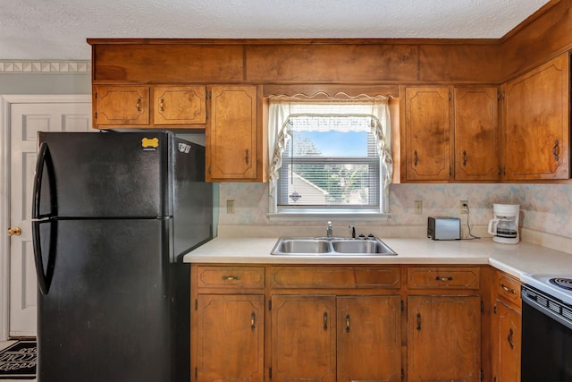 303 Furnace Hollow Rd, Dickson, TN 37055 - kitchen with freestanding refrigerator, a textured ceiling, light countertops, and brown cabinets