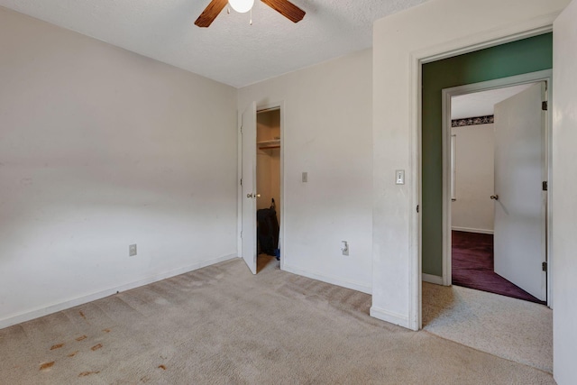 303 Furnace Hollow Rd, Dickson, TN 37055 - unfurnished bedroom featuring carpet, a textured ceiling, a ceiling fan, a walk in closet, and a closet