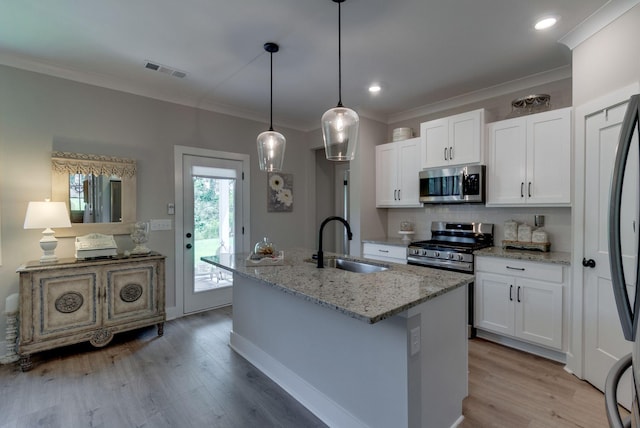 588 Davis Valley Dr, Columbia, TN 38401 - kitchen with appliances with stainless steel finishes, crown molding, light wood-style floors, light stone countertops, and a center island with sink
