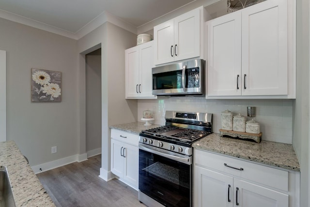 588 Davis Valley Dr, Columbia, TN 38401 - kitchen with appliances with stainless steel finishes, decorative backsplash, light wood-style flooring, ornamental molding, and light stone countertops