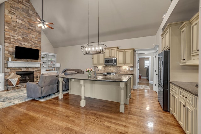 122 Ridgebend Dr, Murfreesboro, TN 37128 - kitchen featuring cream cabinets, appliances with stainless steel finishes, open floor plan, ceiling fan, and dark stone countertops