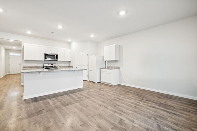 8044 Typhani Way, White House, TN 37188 - kitchen with stainless steel microwave, freestanding refrigerator, stove, recessed lighting, and light wood finished floors