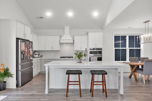 373 Hammock Ln, Spring Hill, TN 37174 - kitchen with appliances with stainless steel finishes, premium range hood, vaulted ceiling, a kitchen breakfast bar, and light countertops