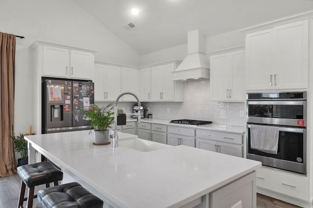 373 Hammock Ln, Spring Hill, TN 37174 - kitchen featuring appliances with stainless steel finishes, custom range hood, dark wood-type flooring, decorative backsplash, and a breakfast bar