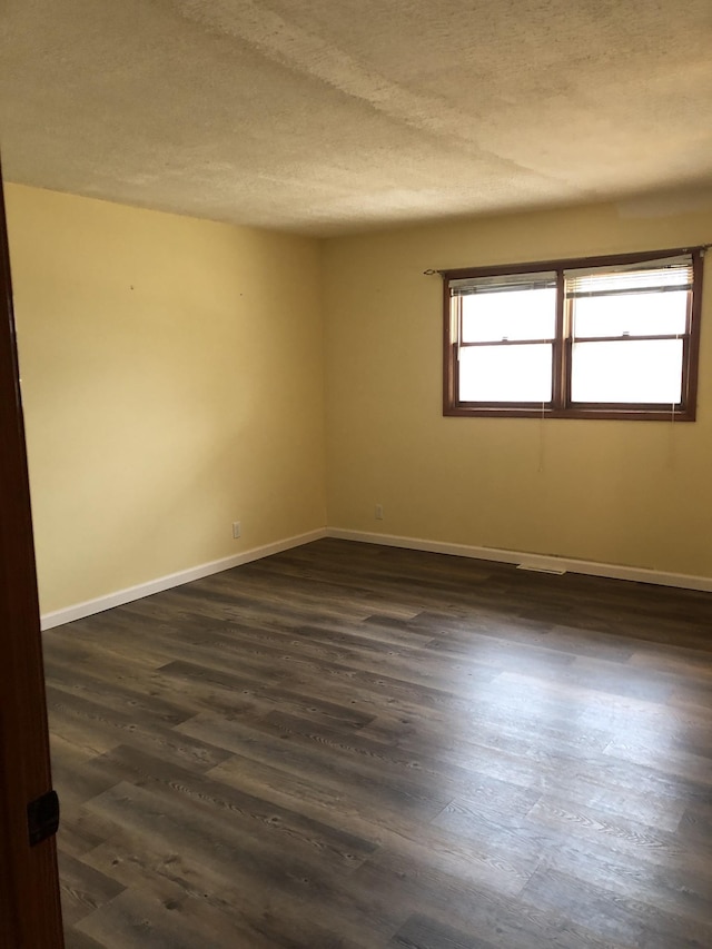 233 W Chestnut St, Puryear, TN 38251 - empty room featuring healthy amount of natural light, a textured ceiling, and dark wood finished floors