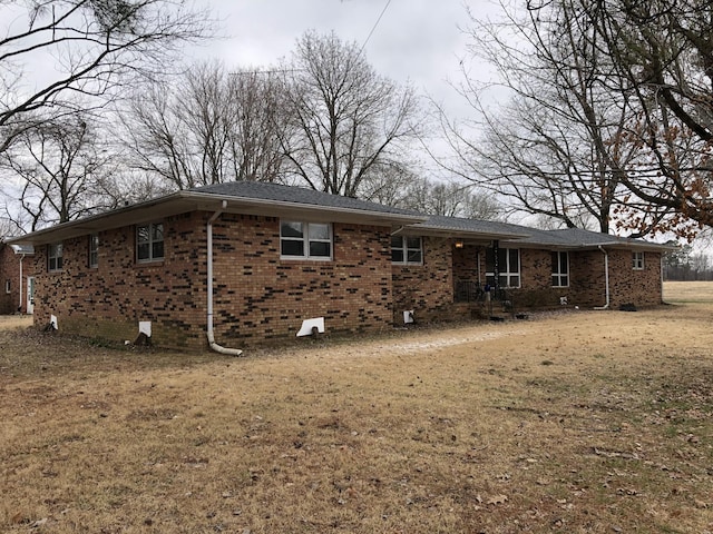 233 W Chestnut St, Puryear, TN 38251 - rear view of property featuring brick siding and a lawn