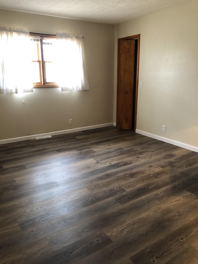 233 W Chestnut St, Puryear, TN 38251 - empty room featuring dark wood-style floors and a textured ceiling