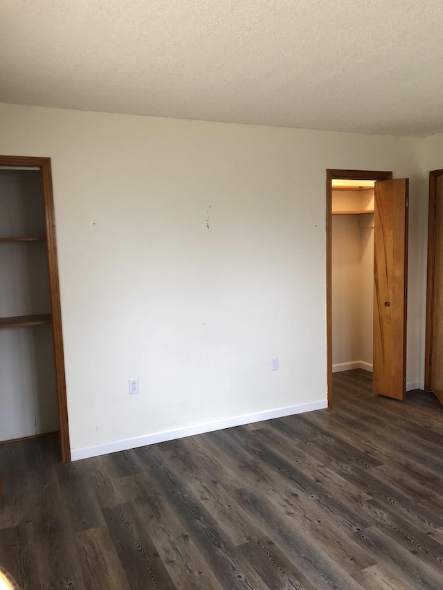 233 W Chestnut St, Puryear, TN 38251 - unfurnished bedroom with a spacious closet, a closet, and dark wood finished floors