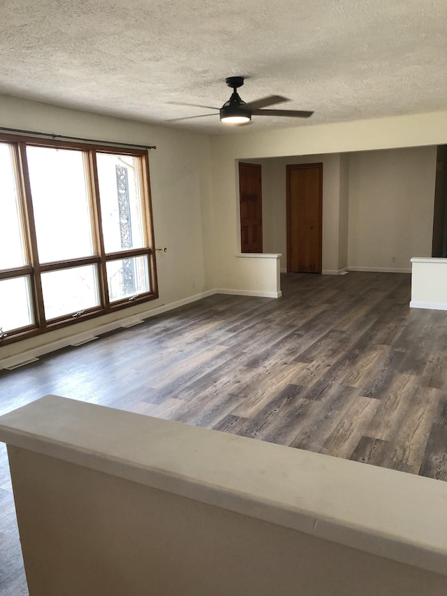 233 W Chestnut St, Puryear, TN 38251 - empty room with a textured ceiling, dark wood-type flooring, and ceiling fan