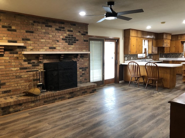 233 W Chestnut St, Puryear, TN 38251 - kitchen with a peninsula, ceiling fan, brown cabinets, wood finished floors, and light countertops