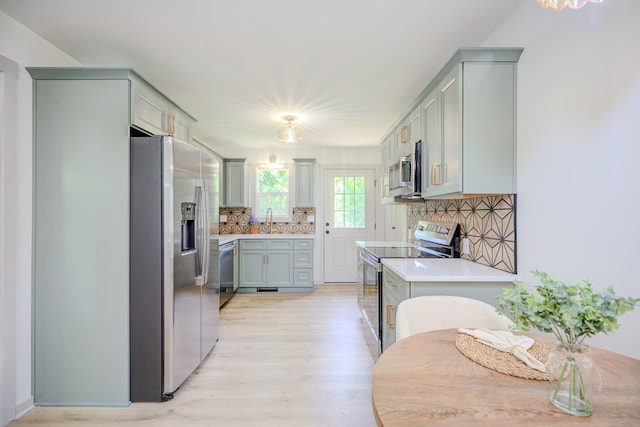445 High Point Rd, Clarksville, TN 37042 - kitchen featuring appliances with stainless steel finishes, light wood-style flooring, decorative backsplash, and light countertops