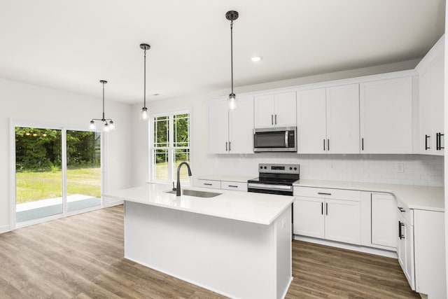 4026 Rampart Way, Spring Hill, TN 37174 - kitchen featuring stainless steel appliances, backsplash, light countertops, an island with sink, and dark wood-type flooring