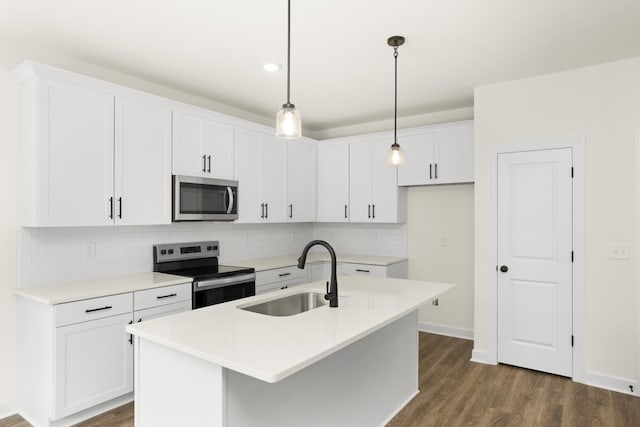 4026 Rampart Way, Spring Hill, TN 37174 - kitchen featuring appliances with stainless steel finishes, decorative backsplash, white cabinets, a kitchen island with sink, and dark wood finished floors