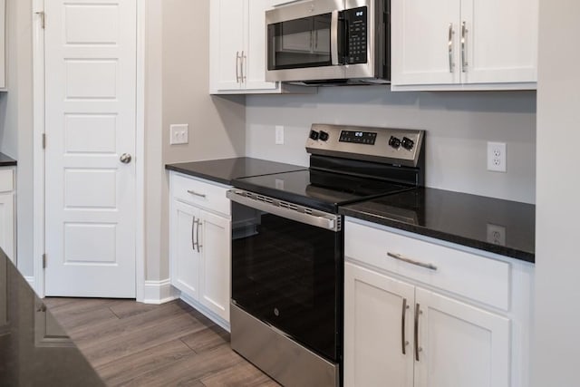 30 Cherry Acres, Clarksville, TN 37042 - kitchen featuring appliances with stainless steel finishes, white cabinetry, dark wood-style floors, and dark countertops