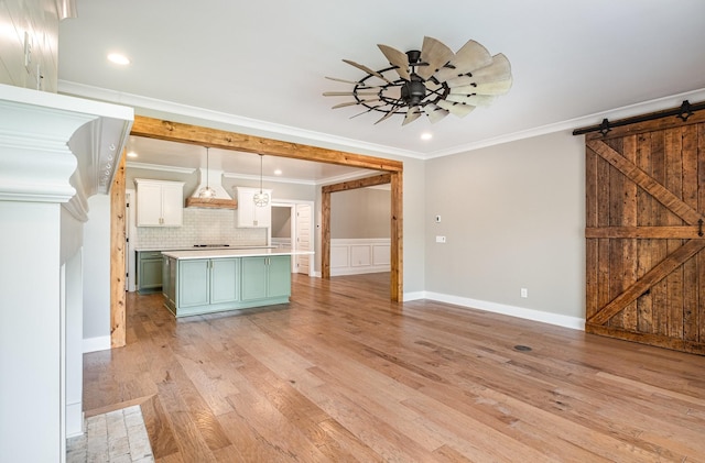 2050 Beamon Dr, Franklin, TN 37064 - kitchen featuring green cabinetry, a barn door, crown molding, light wood-style floors, and light countertops