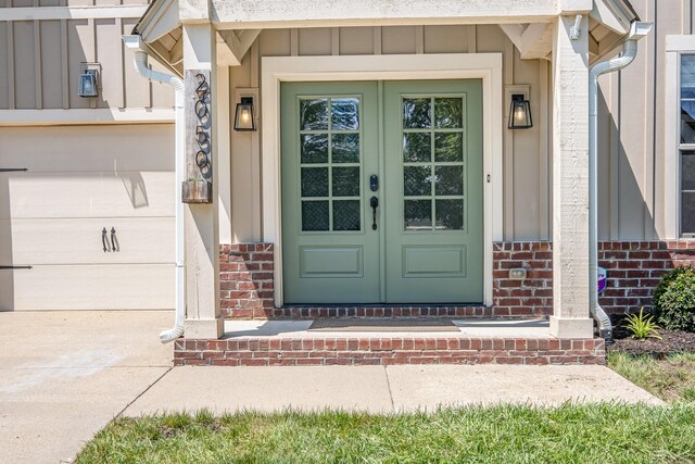 2050 Beamon Dr, Franklin, TN 37064 - entrance to property featuring french doors, brick siding, a garage, concrete driveway, and board and batten siding