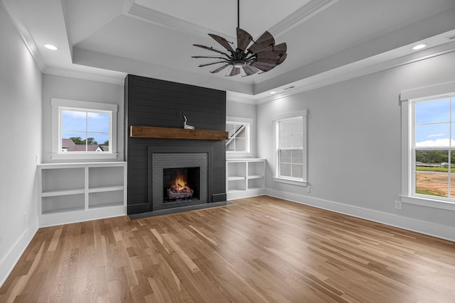 5937 Hunt Valley Dr, Spring Hill, TN 37174 - unfurnished living room featuring a tray ceiling, ornamental molding, light wood-style floors, a large fireplace, and recessed lighting