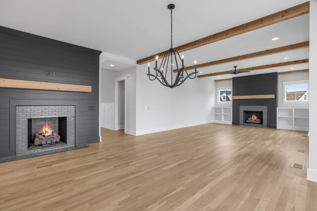 5937 Hunt Valley Dr, Spring Hill, TN 37174 - unfurnished living room featuring a large fireplace, beam ceiling, recessed lighting, light wood finished floors, and a chandelier
