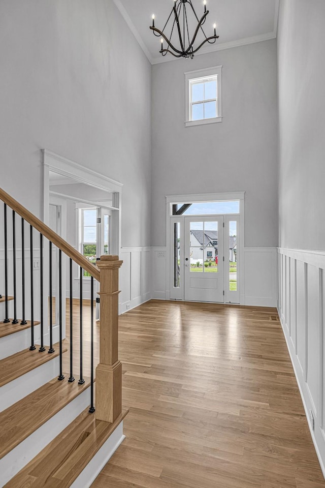 5937 Hunt Valley Dr, Spring Hill, TN 37174 - entryway featuring a chandelier, crown molding, a towering ceiling, stairs, and a wainscoted wall