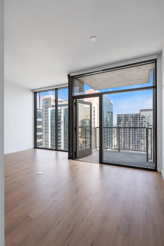 1212 Demonbreun St Unit A9 L, Nashville, TN 37203 - empty room featuring floor to ceiling windows, a view of city, and wood finished floors