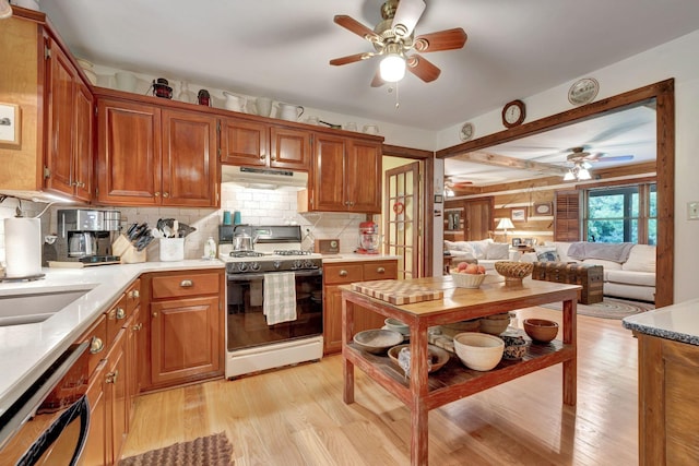 6861 Arno Allisona Rd, College Grove, TN 37046 - kitchen featuring white gas range, under cabinet range hood, a ceiling fan, and light wood-style flooring