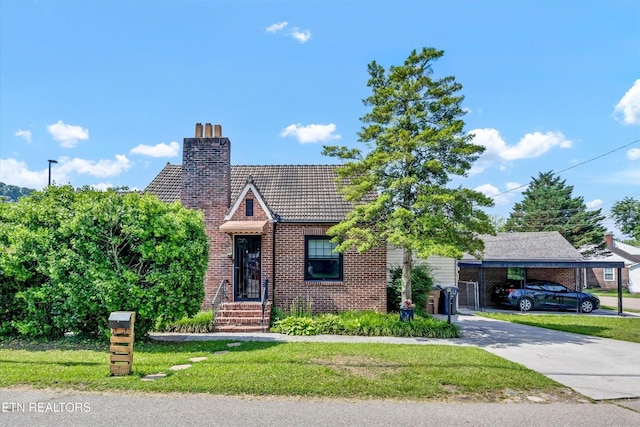 4616 Coile Rd, Knoxville, TN 37918 - tudor home featuring a chimney, brick siding, a front yard, and a tile roof