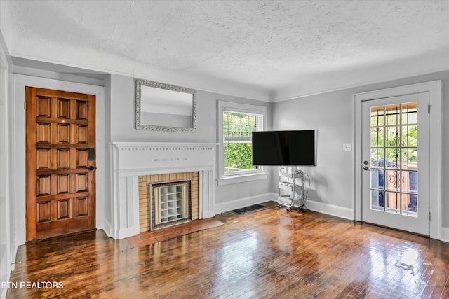 4616 Coile Rd, Knoxville, TN 37918 - unfurnished living room featuring a textured ceiling, wood finished floors, and a brick fireplace