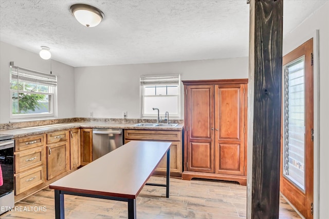 4616 Coile Rd, Knoxville, TN 37918 - kitchen featuring dishwasher, a textured ceiling, light wood finished floors, and brown cabinetry
