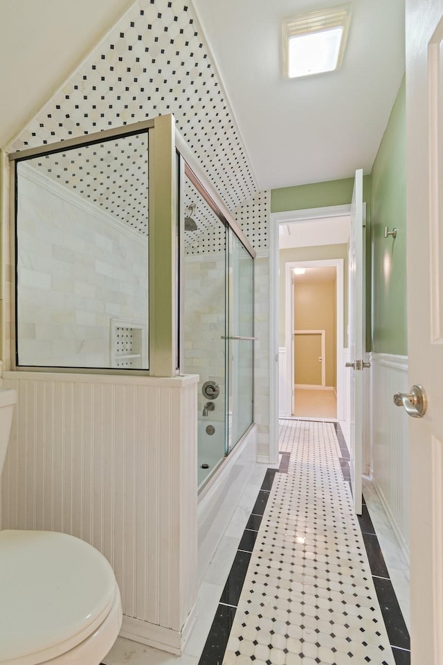 1111 Chickasaw Dr, Brentwood, TN 37027 - full bathroom featuring combined bath / shower with glass door, a wainscoted wall, inlaid floor details, and tile patterned flooring