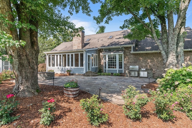 1111 Chickasaw Dr, Brentwood, TN 37027 - rear view of property featuring a sunroom, a chimney, a patio, entry steps, and a shingled roof