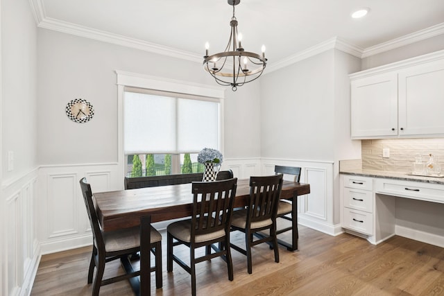1037 Jackston Mack Way, Gallatin, TN 37066 - dining area with a chandelier, a decorative wall, light wood-style floors, wainscoting, and ornamental molding